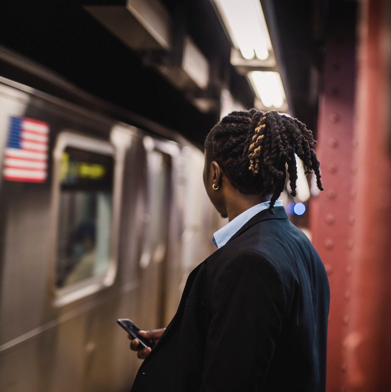 man in suit looking at arriving train on subway